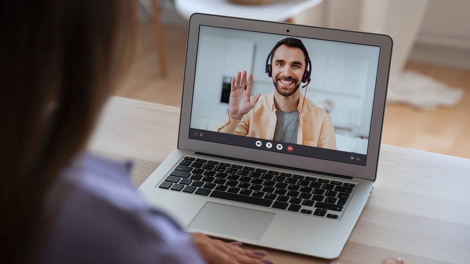 Person on a video call at a laptop, surrounded by office items and custom promotional gifts, illustrating how these products reinforce the brand and build connection with clients and employees.